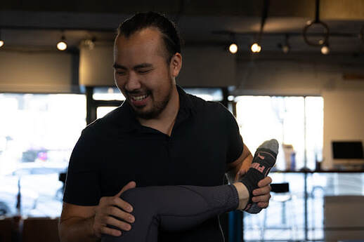 Manual osteopath assessing a client's arm